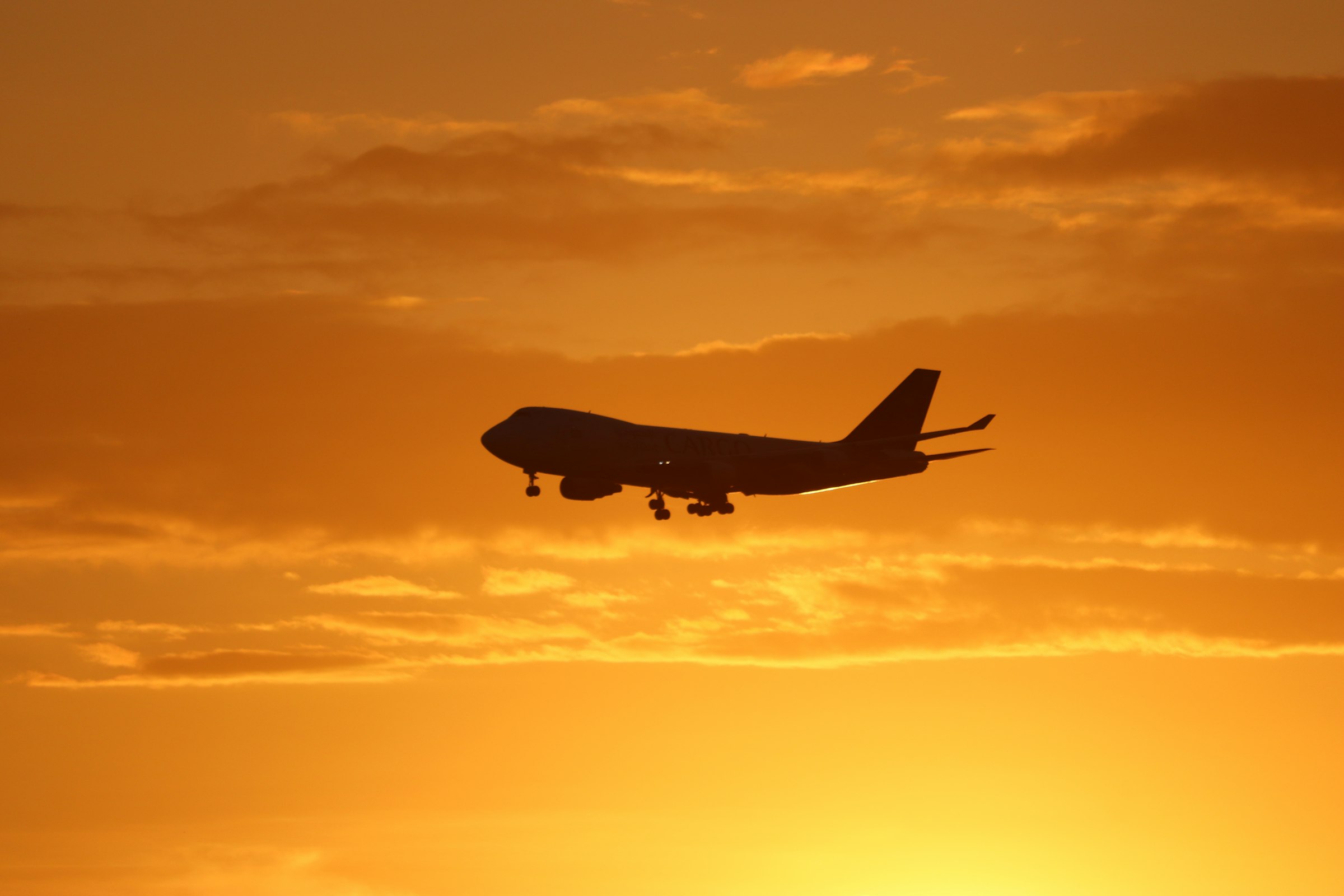 A cargo aircraft against a golden sunset sky